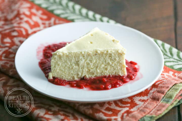 Healthy Instant Pot Recipes: Plain Cheesecake on a white plate with red berry sauce